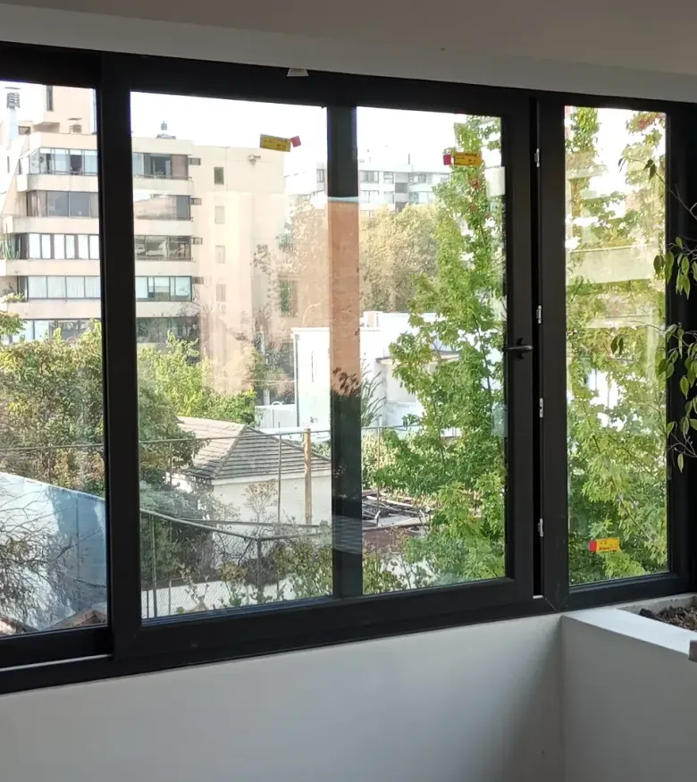 Ventanal de PVC con termopanel instalado en una vivienda, con vista al exterior