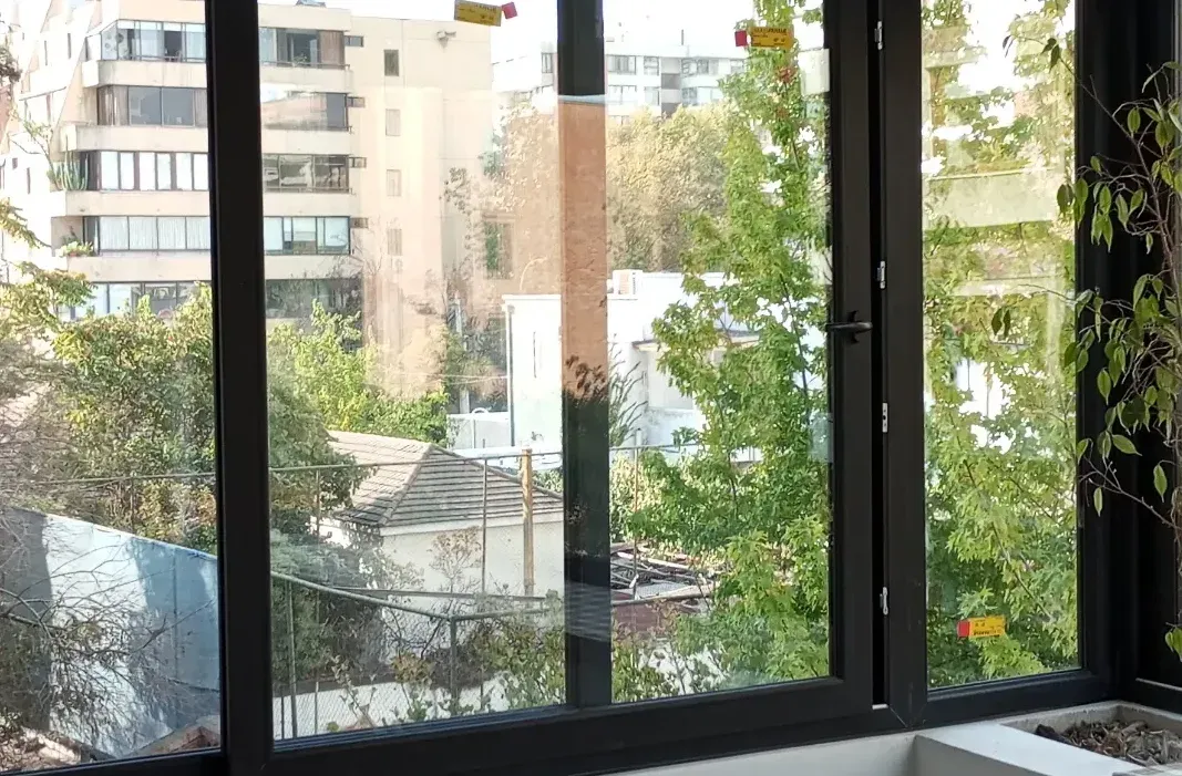 Ventana oscilobatiente de PVC con una hoja abierta hacia el jardín